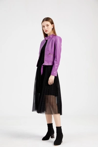 Full body shot of a woman in purple faux leather jacket and black pleated mesh skirt