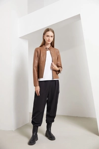 Detail view of brown leather jacket featuring stand collar and quilted waist stitching