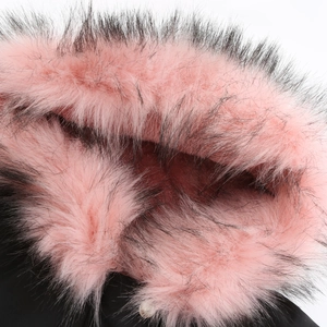 Detail of pink faux fur hood trim with black tips and white button on parka coat