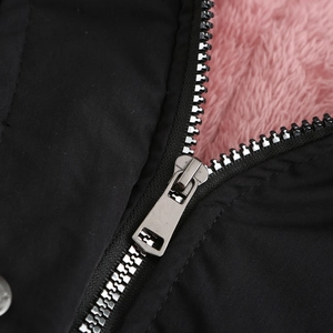 Detail of premium silver metal zipper with soft pink faux fur lining on a black parka jacket
