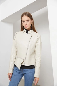 Detail of silver rivets on shoulders of cream faux leather moto jacket with stand collar