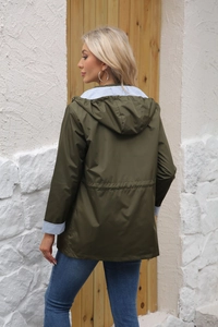 Detail of army green windbreaker with adjustable drawstring waist and striped lining