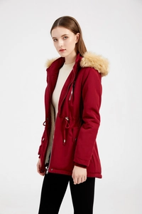 Dettaglio del parka rosso scuro con cappuccio in finta pelliccia rimovibile e coulisse