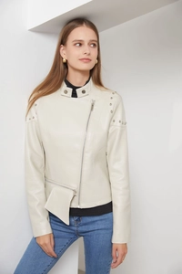 Detail of studded shoulders and stand collar on a cream white faux leather biker jacket