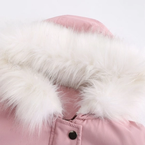 Gros plan d'une parka rose avec un col en fausse fourrure blanche et un bouton noir