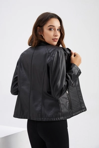 Rear view of black faux leather biker jacket with quilted side panels and a stand collar