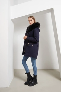 Deep blue women parka coat with faux fur hood and adjustable waist in a white minimalist set