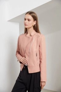 Detailed view of pink faux leather biker jacket with silver stud rivets on the shoulders