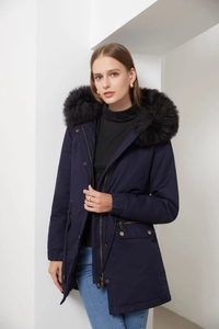 Detail of navy blue winter parka featuring plush black faux fur hood and golden zippers