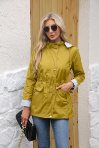 Detail of hooded trench coat with stripe lining, drawstring waist, and metal buttons