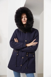 Detail of navy blue winter parka featuring large faux fur hood and drawstring waist