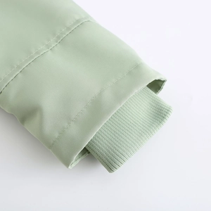 Détail des poignets coupe-vent côtelés et du tissu vert menthe de la veste parka