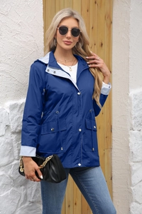 Detail of navy trench coat featuring striped lining on the hood and sleeve cuffs