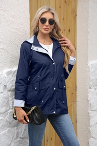 Detail of navy blue trench coat with adjustable drawstring waist and striped inner lining