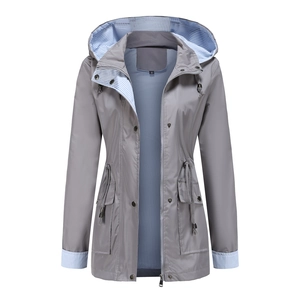 Detailed view of women's grey hooded windbreaker with blue striped lining and drawstring