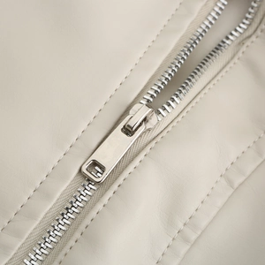 Detailed close-up of high-quality silver metal zipper on cream leather jacket