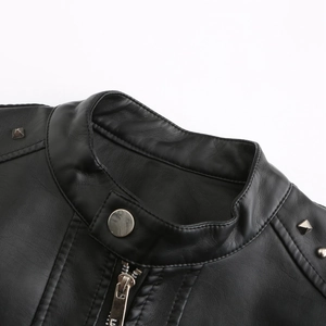 Detail eines Stehkragens mit silbernen Nieten und Metallreißverschluss an schwarzer Lederjacke