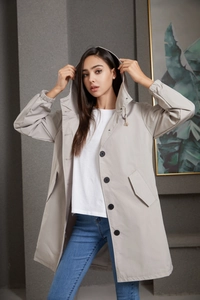 Detail of water-resistant hooded trench coat with black buttons and elastic cuffs
