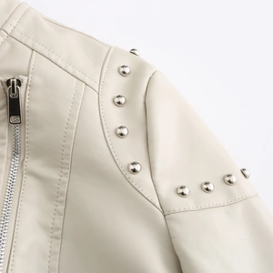 Detail of beige faux leather jacket featuring silver studs and high-quality stitching