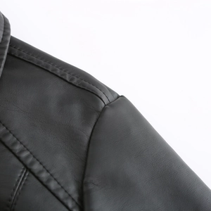Vue détaillée de l'épaule d'une veste en cuir noir avec coutures matelassées et fini mat