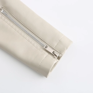 Detail of cream leather jacket sleeve featuring silver metal zipper and neat stitching