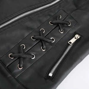 Détail d'une veste en cuir noir avec fermetures éclair argentées et laçage croisé élégant