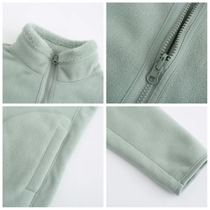 Detail view of light green fleece jacket featuring stand collar, zipper and ribbed cuffs