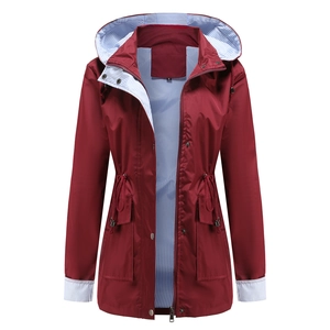 Detail of burgundy waterproof raincoat featuring striped lining and adjustable drawstring waist
