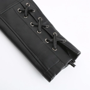 Détail de la manche d'une veste en cuir noir avec œillets métalliques et lacets tissés