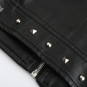 Detail einer schwarzen Lederjacke mit silbernen Metallnieten und hochwertigem Reißverschluss