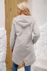 Rear view of a light grey women's hooded windbreaker with elastic cuffs and split hem detail