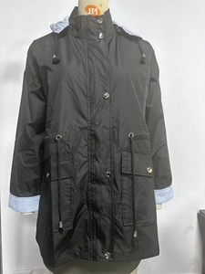 Detail of hooded trench coat showing blue striped lining and adjustable drawstring waist