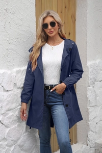 Detail of water-resistant hooded trench coat with black buttons and elastic cuffs