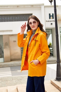Detail eines leuchtend orangefarbenen Kapuzenwindbreakers mit Kordelzügen und Taschen