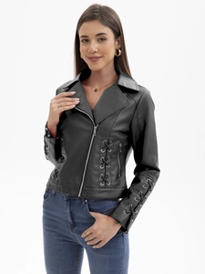 Détail d'œillets métalliques et de laçage croisé sur une veste noire en similicuir