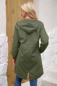 Macro view of water-resistant green parka featuring adjustable drawstring waist and hood detail