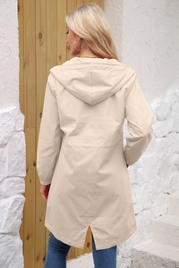 Back view of a long hooded water-resistant windbreaker in beige with a split hem detail