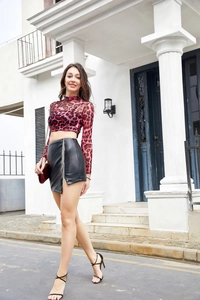 Détail de la mini-jupe en cuir PU noir avec fente latérale et chaînes à franges argentées