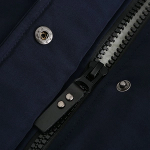 Detail of dark navy windproof parka with resin zipper and star-engraved silver buttons