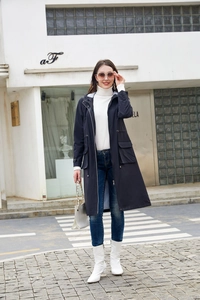 Long navy hooded trench coat with drawstring waist and stripe lining on city street