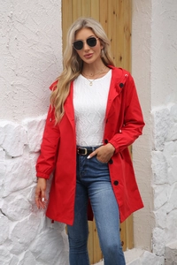 Detail of red water-resistant hooded windbreaker featuring black buttons and elastic cuffs