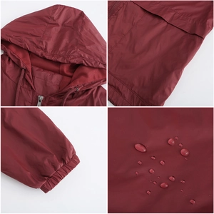 Détails du tissu imperméable d'une veste coupe-vent à capuche rouge foncé