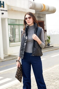 Detail of black faux leather padded vest with stand collar and hidden zip closure