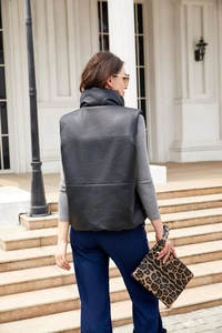 Rear view of women's black faux leather padded vest with stand collar and paneled stitching