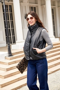 Detail of black faux leather padded vest with stand collar and zipper closure