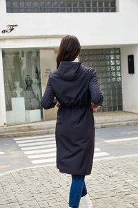 Back view of a long navy blue hooded windbreaker with adjustable drawstring waist details