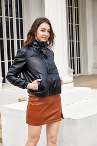 Detail of a black faux leather puffer jacket featuring a high stand collar and side pockets