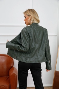 Detail view of the back and side of a dark green faux leather jacket with zipper cuffs
