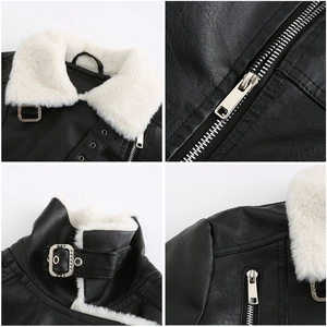 Détail de la veste en cuir noir avec col en fausse fourrure blanche et boucles argentées
