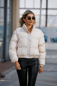 Detail shot of beige short padded jacket featuring a stand collar and adjustable hem